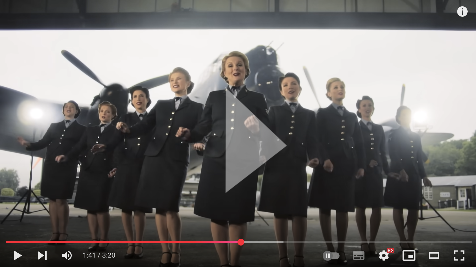 Women in RAF uniform singing in front of plane